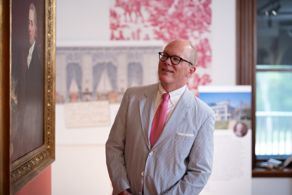 Tripp Evans, guest curator of The Importance of Being Furnished exhibit, smiles while viewing a painted portrait.