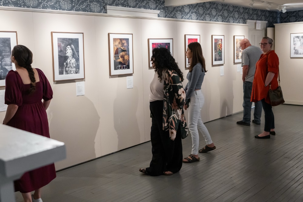 Visitors view Lokotah Sanborn's collages on display as part of the Wαpánahkəyak exhibit at the Sarah Orne Jewett House.