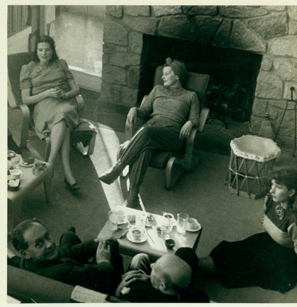 A black and white photo of the Gropius family seated in front of a large fireplace.