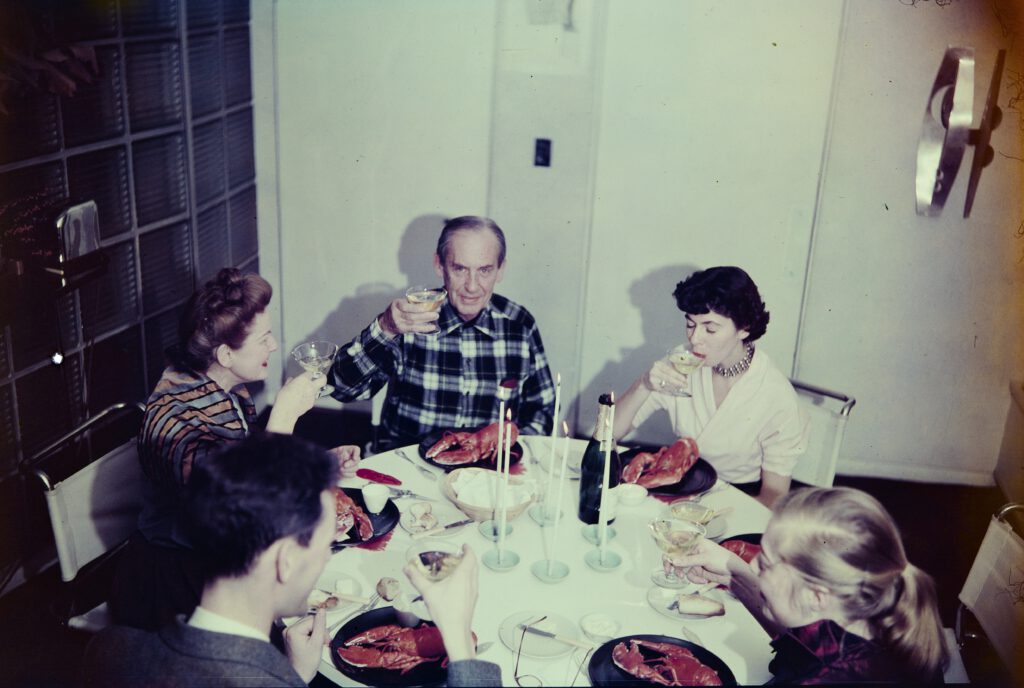 A photo showing Ise, Walter, and Ati Gropius at the dining room table in Gropius House.