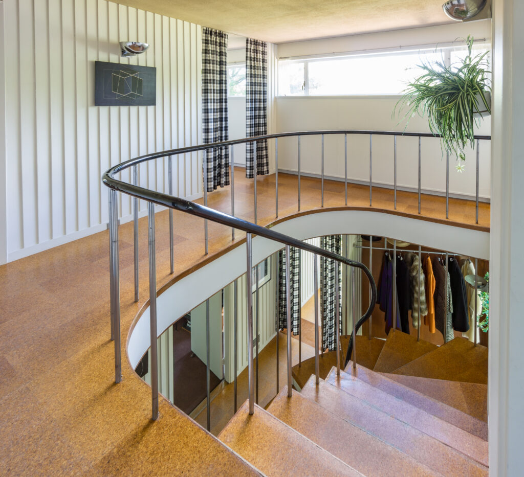 A photo from the top of a wooden staircase inside of Gropius House.