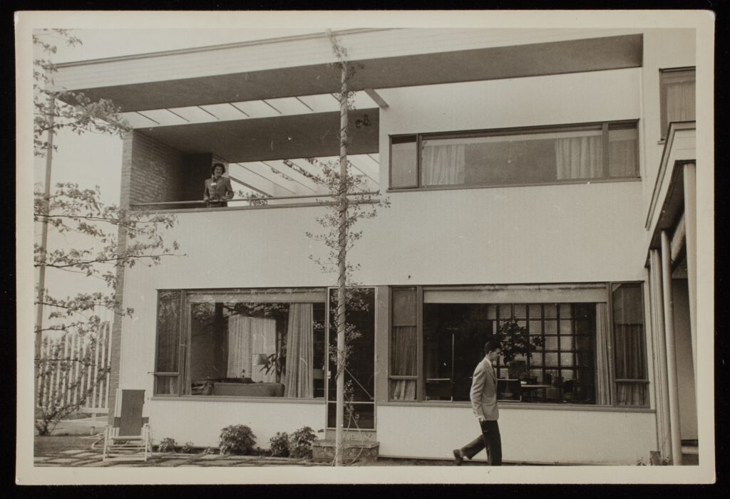 A photo of a man walking past the outside of Gropius House.