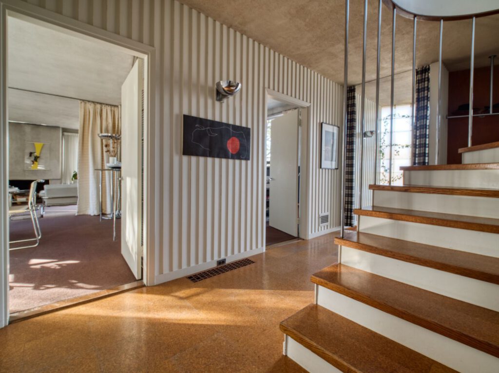 A photo of a hallway in Gropius house showing entrances to two rooms and the bottom of a staircase.