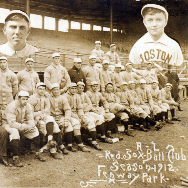 A team photo of the 1912 Red Sox Ball Club at Fenway Park. The baseball players are dressed in their uniforms including white caps, and three team members who were not present for the photo have had their floating heads and torsos added to the image.