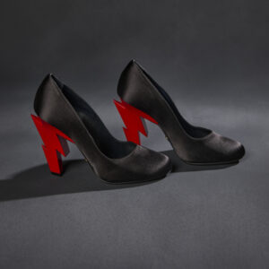 A pair of satin black high heels with a jagged red lightning bolt for each heel.