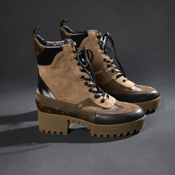 A pair of large leather boots in tan, brown, and black leather. These fashion boots have the Louis Vuitton symbol stamped above the toe, visible tread on the full sole including the arch, and various suede textures.