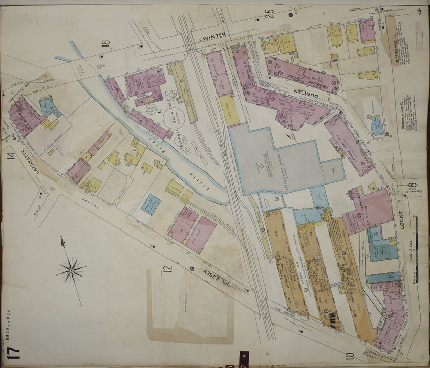 A map showing the triangular area between Essex Street, Winter Street, and Locke Street. The railroad tracks divide the image at center, with surrounding brick and wood buildings visible. There are three brown-gray (fireproof) buildings at bottom left, all parallel to each other, that are labeled “Various Shoe Mfg.”