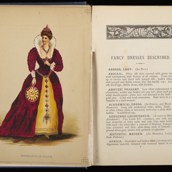 A book shown open. On the left page, an elaborate illustration of Marguerite de Vaois with a high ruffle around her neck and a sumptuous red and gold dress carrying a fan. On the right page, a list of “fancy dresses described” including various costumes.