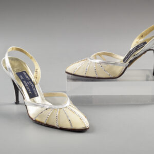 A pair of silver high heels with a toe of transparent mesh decorated with radiating lines of clear rhinestones and a silver back strap.