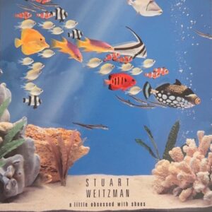 A colorful school of fish in the shape of a shoe swims in an aquarium. At the bottom, "Stuart Weitzman: a little obsessed with shoes."