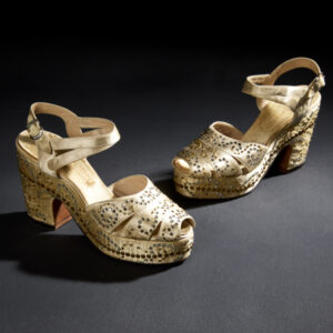 Light tan platform sandals with swirls of grey and gold rhinestones across the sides, heels, and stacked toe straps.