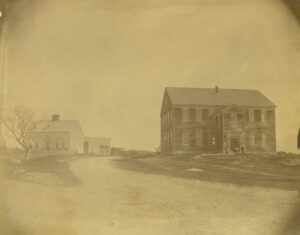 Sepia image of Rocky Hill Meeting House in foreground with parsonage to the west of the Meetinghouse.