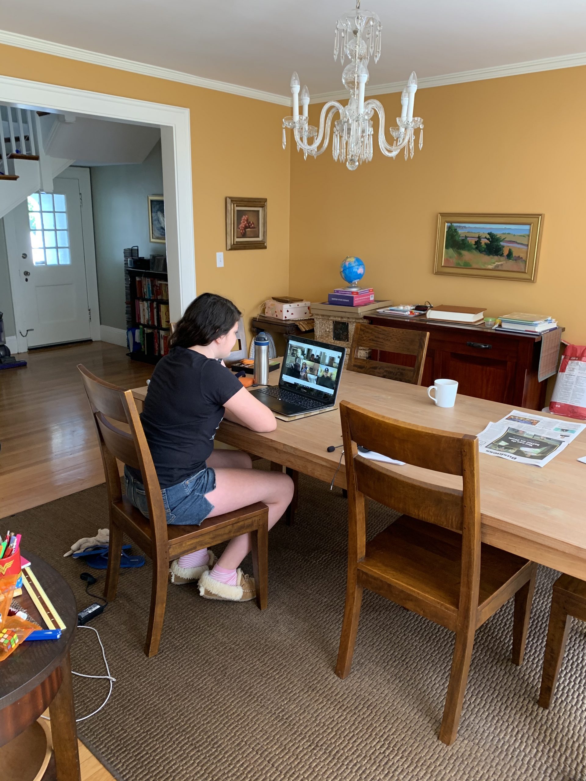Fifth grader sits at kitchen table finishing virtual school on her laptop.