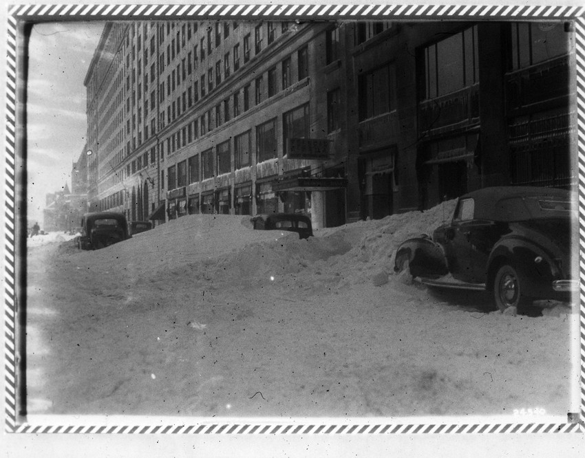 Automobiles are buried in snow next to the Park Square Building on St. James Avenue.