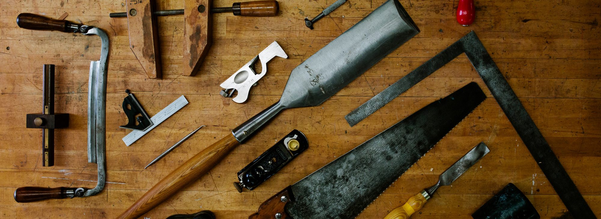 Various carpentry tools arranged on a wood table.