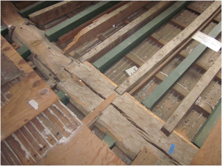 Wooden beams painted green used as a frame in a building.
