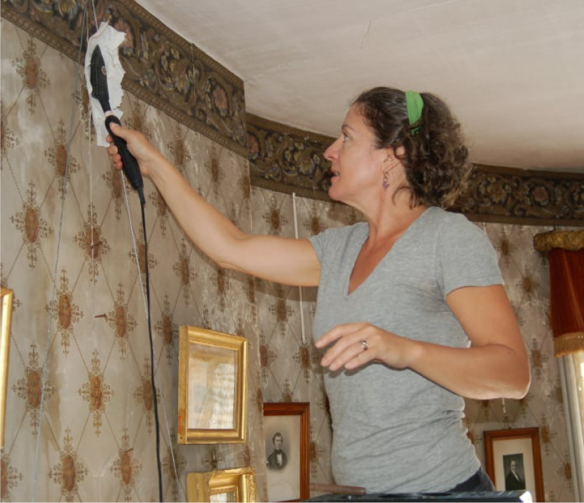Woman repairing wallpaper