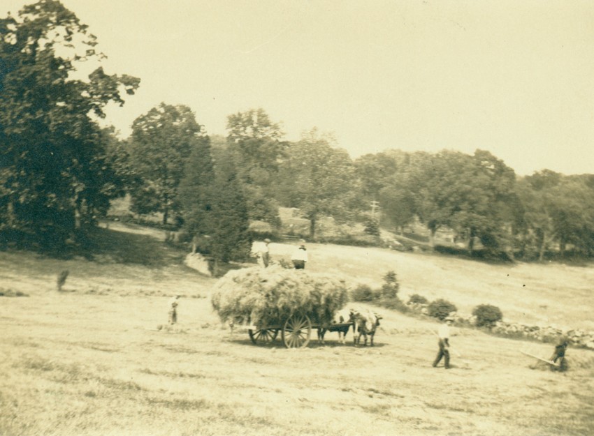 Sepia photo of hay wagon and workers in the field