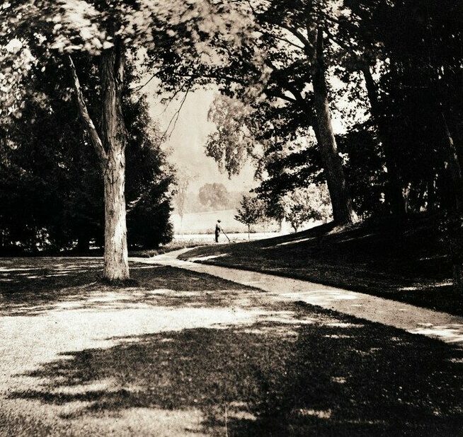 Black and white image of grounds worker in landscape