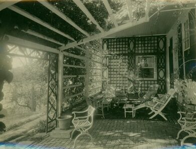 Black and white photo of trellis-covered porch