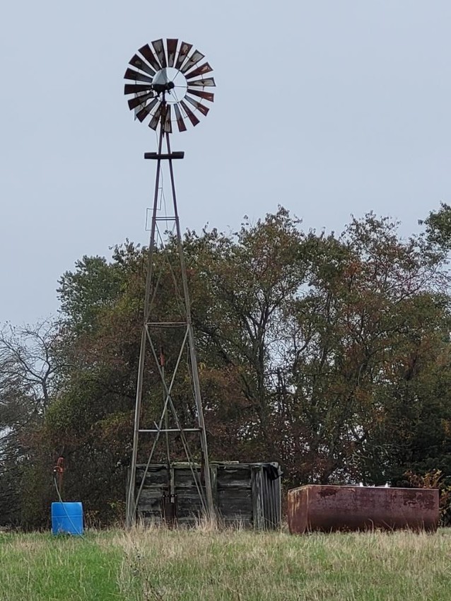 Windmill in a field with water tank at base.