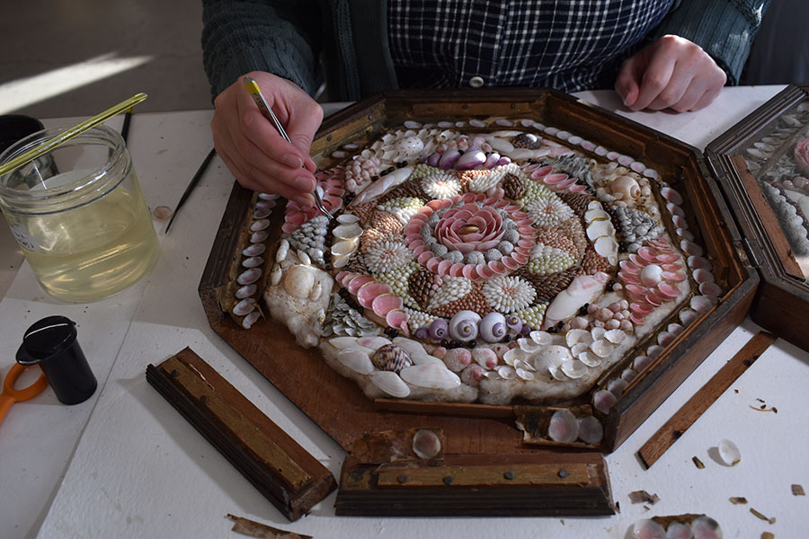 Detail of conservation work to readhere shells and other materials in a piece of artwork