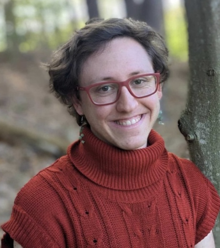 Person in red sweater standing in the woods