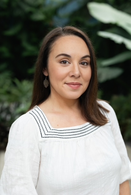 Person with long, dark hair in white top