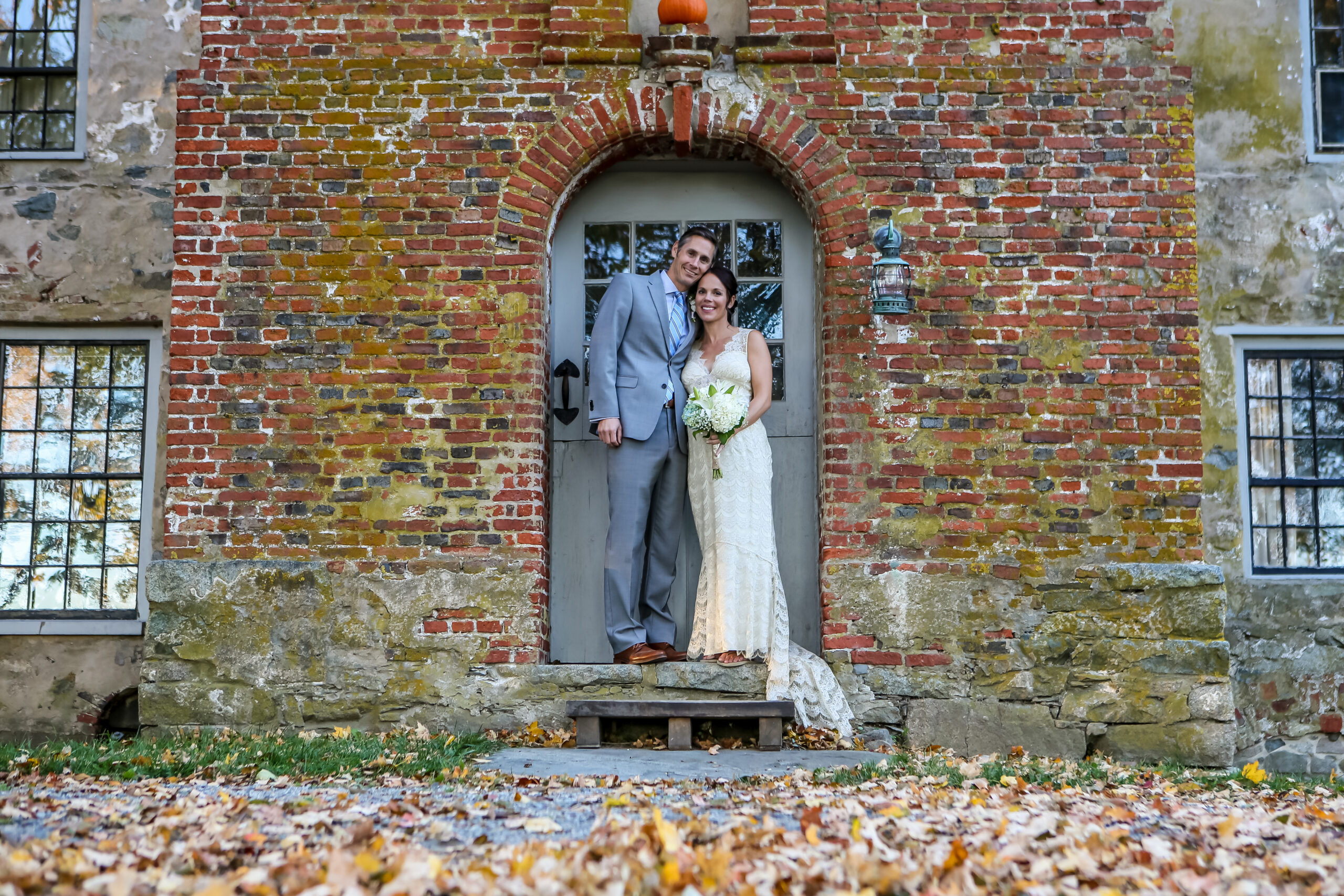 Bride and groom in brick doorway arch