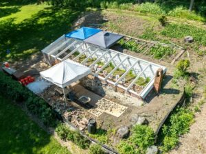 Aerial view of restoration work on the bark pit greenhouse. A series of framed panels on a brick foundation.