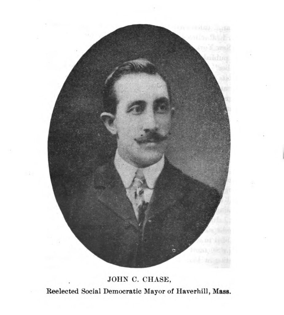 Black-and-white portrait of a man in a suit with a mustache. Transcribed Text: JOHN C. CHASE, Reelected Social Democratic Mayor of Haverhill, Mass.