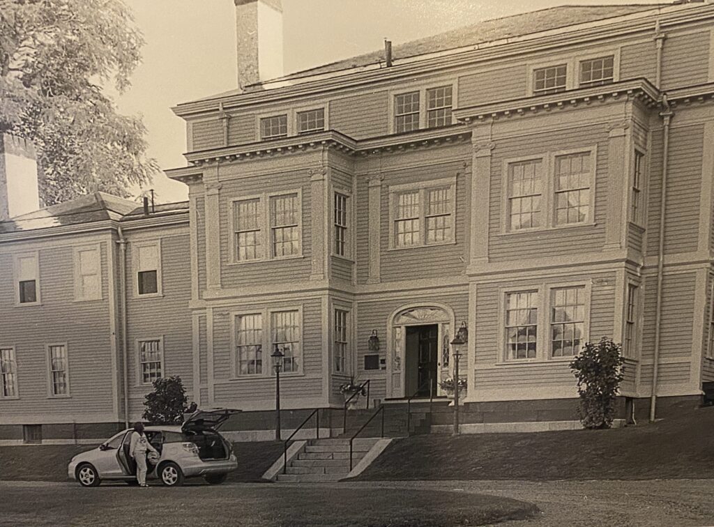 A historic building with decorative windows and an open car hatch in the foreground.
