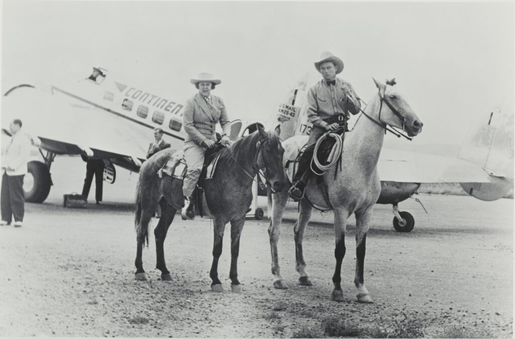 Two people on horseback in front of a vintage airplane with "CONTINENTAL" visible. Transcribed Text: US MAIL AM-24 172