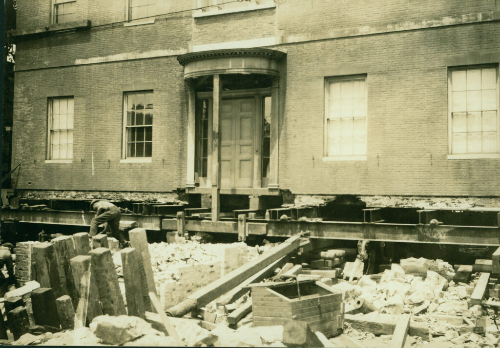 A brick building with visible foundation work and construction debris.
