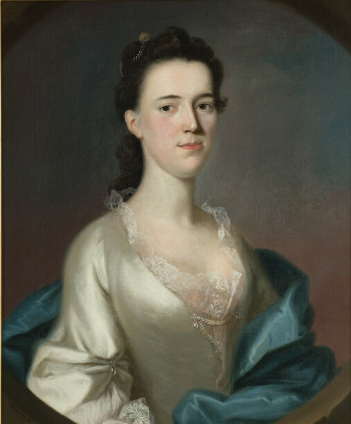 The image is a classic portrait of a woman depicted from the waist up, with a frontal pose and a slight turn to her left. She has dark hair styled in an updo, adorned with a small, decorative piece. Her expression is serene and composed. She is wearing a light, cream-colored gown with delicate lace detailing around the neckline. A rich, blue-green drape is casually wrapped around her shoulders. The background is dark with subtle color gradations, enhancing the subject's features and the elegance of her attire.