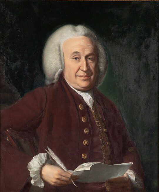 The image is a portrait of an older individual with white hair styled back and a composed expression. The person is wearing a deep burgundy coat with gold buttons and white ruffled cuffs visible at the wrists. They hold a sheet of paper and a quill pen, suggesting a scholarly or literary theme. The background is a dark, muted green, creating a contrast with the subject's lighter attire.