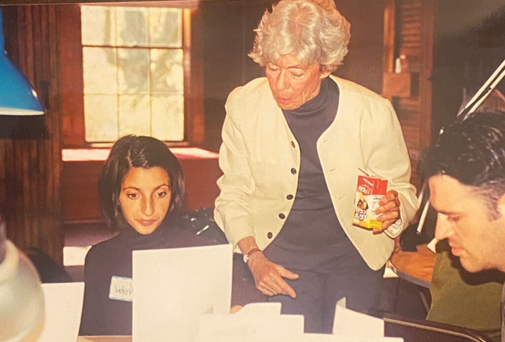 Three people in a room, two women and one man, focused on papers.