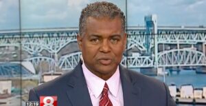 News anchor delivering a broadcast with bridge view in the background. News channel 8 logo onscreen.