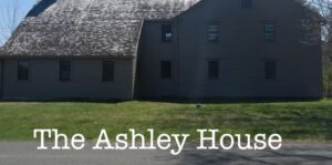 Historic Ashley House with rustic wooden exterior set against a bright, clear sky.