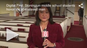 News reporter in church, covering Stonington middle school tribute to an enslaved man's life.