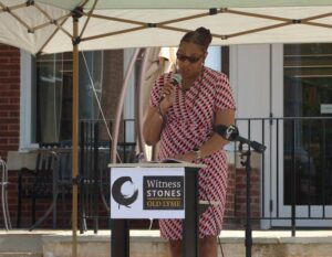 Speaker at Witness Stones Old Lyme event, delivering speech under a canopy.