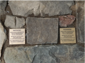 Plaques for Anthony and Susanna, former enslaved individuals in Barbados and Morrisania, on a stone wall.