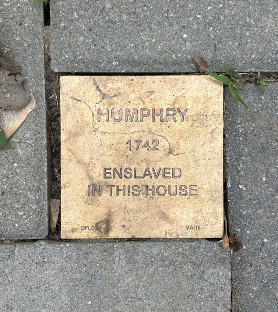 Memorial brick honoring Humphry, enslaved in 1742, installed in a historic pavement setting.