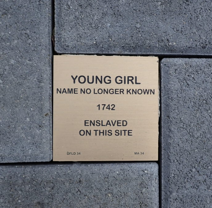 Plaque commemorating an enslaved young girl, name unknown, from 1742, set in stone pavement.