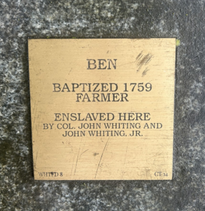 Memorial plaque for Ben, baptized 1759, farmer, enslaved by Col. John Whiting and John Whiting, Jr. on stone surface.