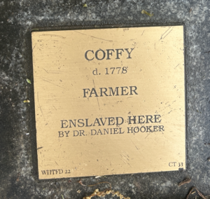 Historical plaque of Coffy, a farmer who died in 1778, highlighting his enslavement by Dr. Daniel Hooker.