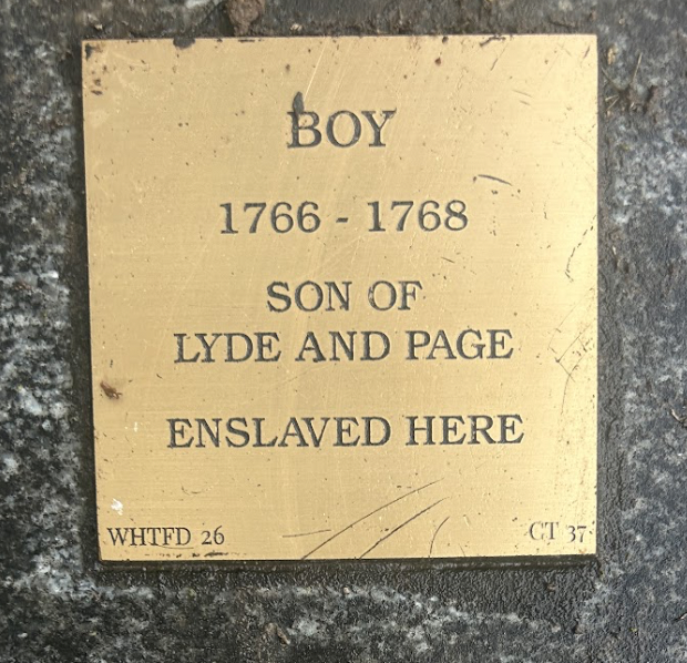 Plaque honoring enslaved boy (1766-1768), son of Lyde and Page. Engraved on stone background.