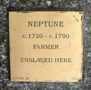 Brass plaque honoring Neptune, a farmer enslaved circa 1720-1790; historical remembrance of slavery.