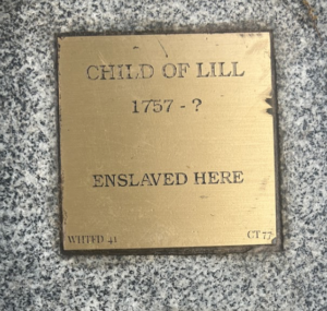 Bronze plaque reading Child of Lill, 1757 - ?, Enslaved Here on a stone base, representing historical remembrance.