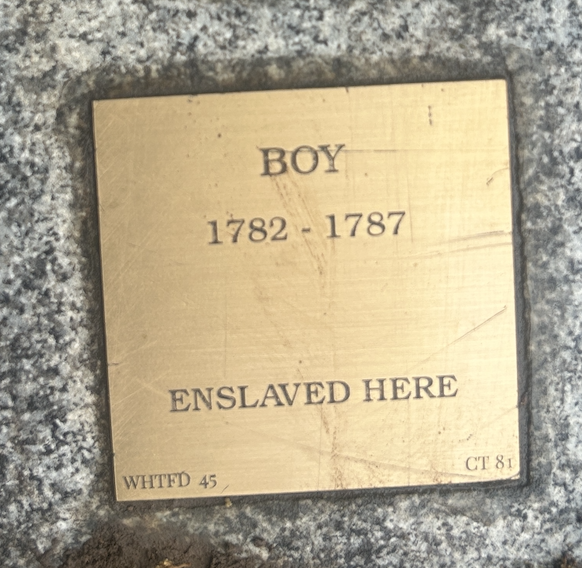 Historical plaque: Boy, 1782-1787, Enslaved Here on a textured surface.